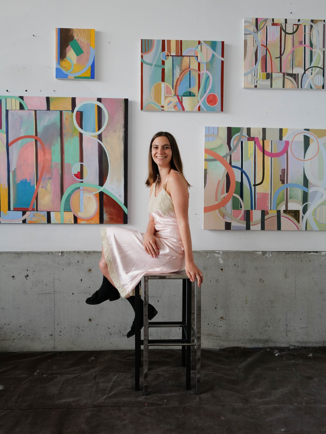 Madeline Bohrer seated in her studio in front of recent paintings